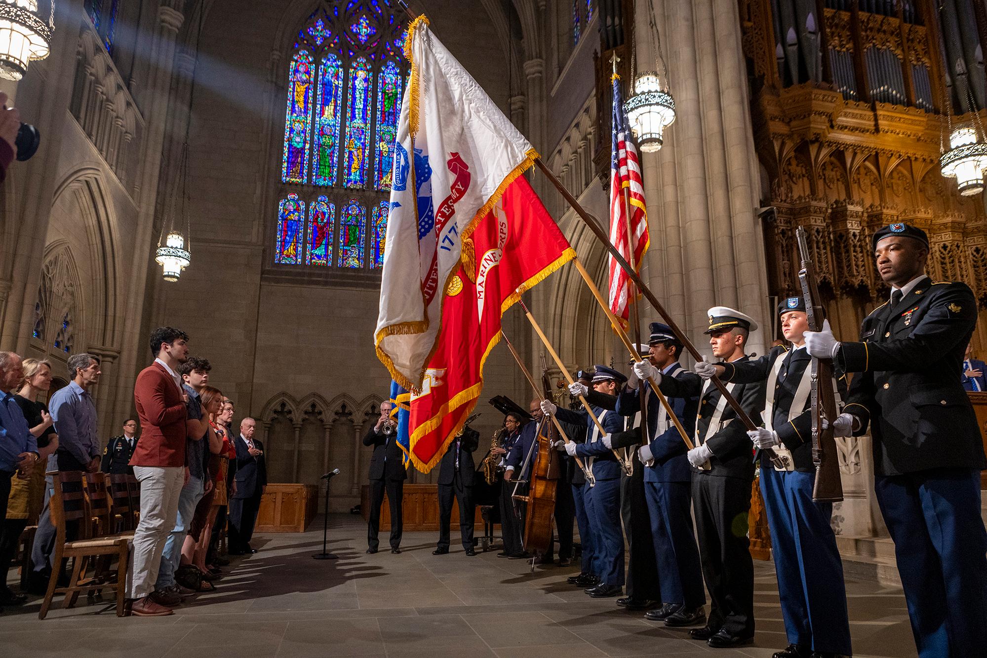 Military service members hold flags for a Veterans Day ceremony in Duke Chapel.