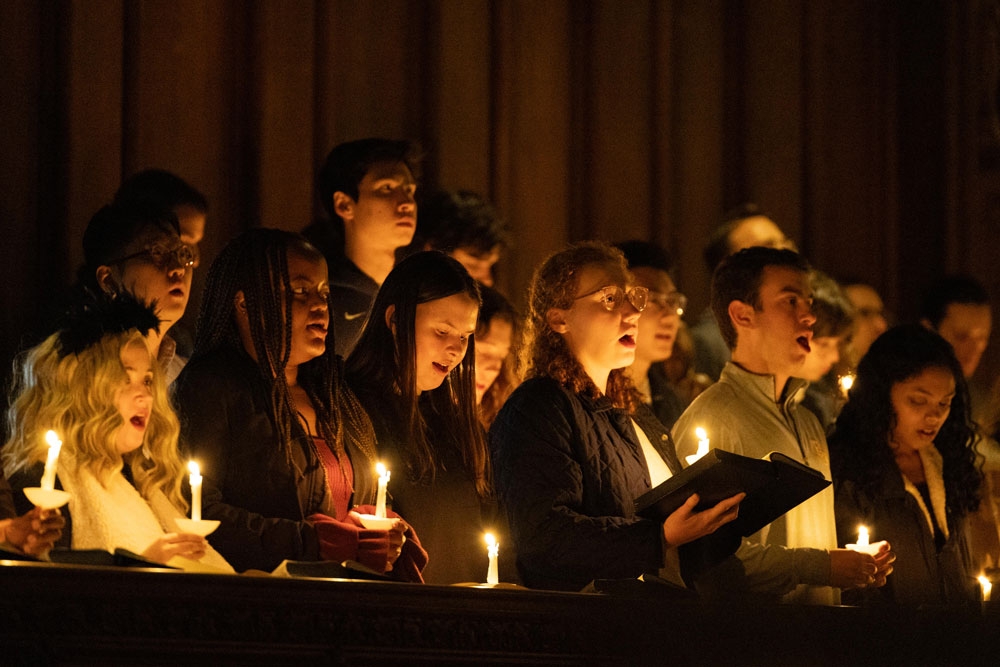 People sing by candlelight at the Chapel's All Hallows' Eve service.