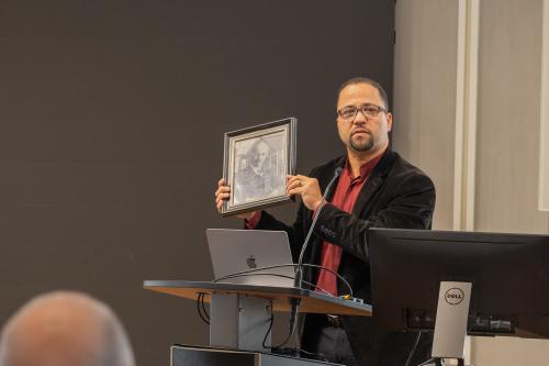 Chapel Dean Luke Powery holds up a meaningful gift he received from Dantzler, a framed photo of Julian Abele, the designer of Duke Chapel.